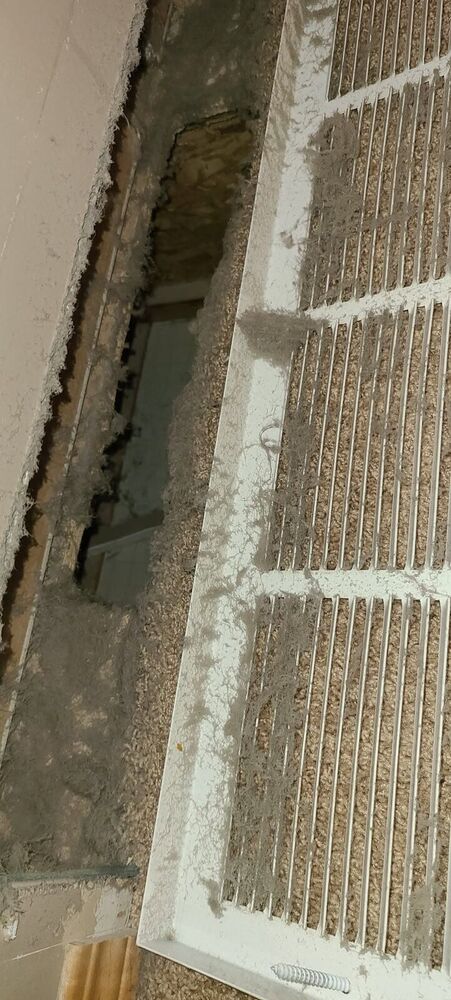 Cold-air return grille so matted with lint the slats are barely visible