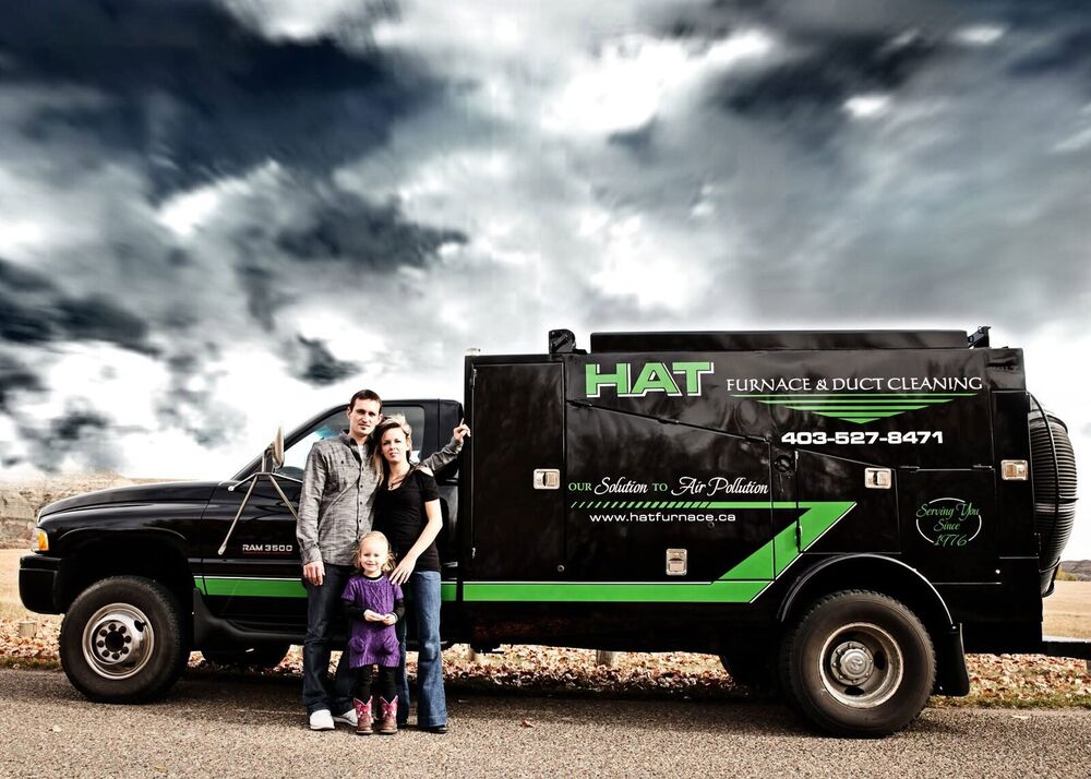 The Huxted family beside the black RAM 3500 vacuum truck in the badlands