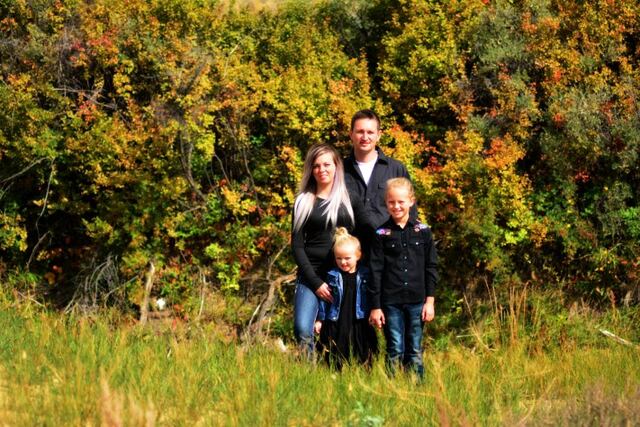 The Huxted family standing together in an autumn coulee
