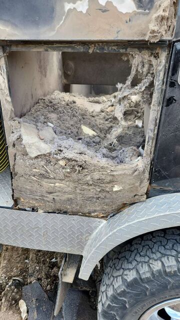 The truck's debris compartment packed full of grey dust and lint collected over many duct cleaning jobs