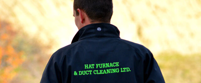 A technician wearing a Hat Furnace & Duct Cleaning Ltd. jacket